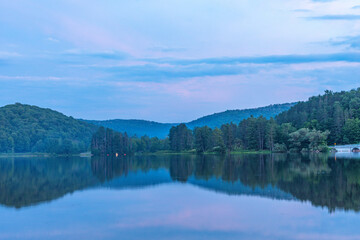 Fototapeta premium Setting sun low light long exposure over mountain lake summer season background image