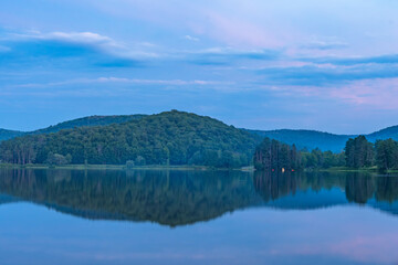 Setting sun low light long exposure over mountain lake summer season background image