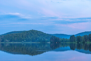 Setting sun low light long exposure over mountain lake summer season background image