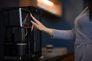 Professional using a touchscreen coffee machine for a convenient coffee break at work