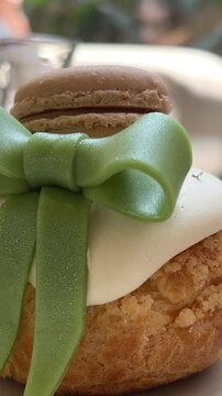 dessert with green bow and macaroon cake custard inside eclair