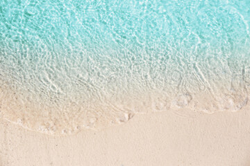 Sea waves rolling on beautiful sandy beach, top view. Summer vacation