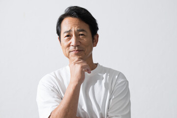 顎に手を当てるシニア男性　50代の美容やスキンケアのイメージ