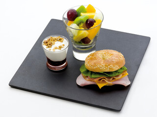 Hamburguesa, macedonia de frutas y helado de queso con frambuesa. Hamburger, fruit salad and cheese ice cream with raspberry.