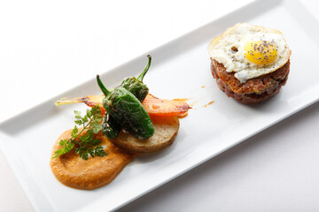 Hamburguesa con huevo frito, patatas y pimientos,  vista cenital. Hamburger with fried egg, potatoes and peppers, overhead view.