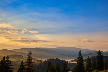 landscape at sunset in the distance with Piatra Craiului mountains from Carpathian Mountains Romania.