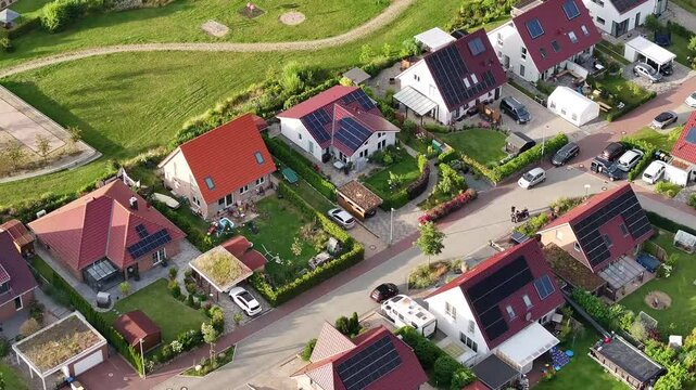 Suburban residential area with single family houses with gardens in a small town in Germany. A green park area behind the houses.