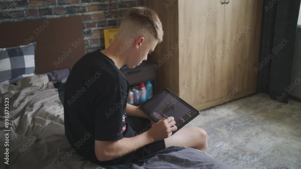 Poster talented boy with digital pencil and tablet in hands sits in room, creates 3d models. focused teenag