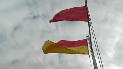 flags on the beach announcing that swimming is dangerous