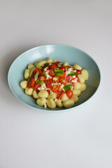Italian gnocchi with tomato sauce with mozarella and basil on plate  on white background