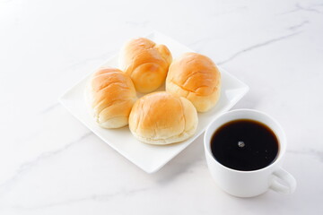 焼きたてで熱々のバターロールと、淹れたてで香りのよいコーヒーが用意された朝食のテーブル
