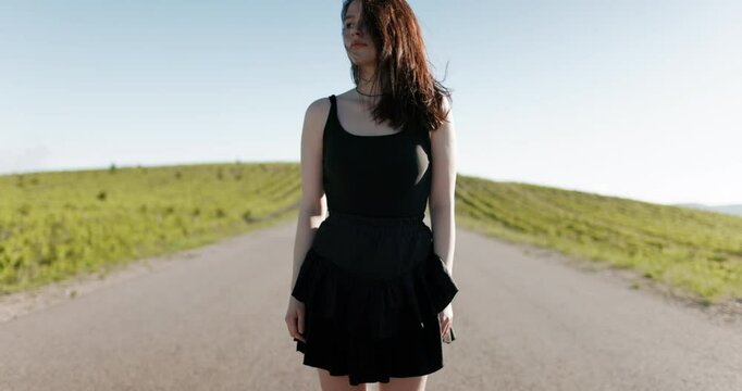 Attractive caucasian woman on roller skates on road way in sunny day. Portrait of sporty girl