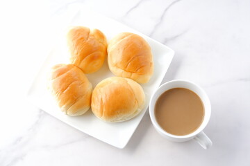焼きたてで熱々のバターロールと、淹れたてのカフェ・オ・レが用意された朝食のテーブル
