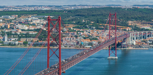 Aerial view of the 25th April Bridge - Ponte 25 de Abril - is a suspension bridge road-rail over the Tagus river that connects the city of Lisbon to the city of Almada. Panoramic view from above.