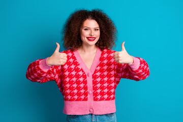 Photo of cheerful pretty lady dressed red cardigan showing two thumbs up empty space isolated blue color background