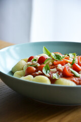 Italian gnocchi with tomato sauce with mozarella and basil on plate 