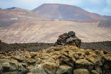 Vulkanlandschaft auf Lanzarote mit Felsformation im Vordergrund