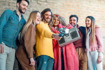 Diverse group of friends filming with smartphone on gimbal, social media content creation and millennial lifestyle concept