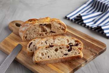 Homemade Bread with Kalamata Olives on a wooden board, side view.