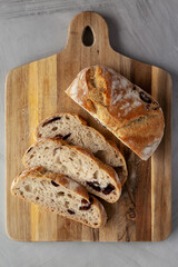 Homemade Bread with Kalamata Olives on a wooden board, top view.