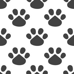 Fototapeta premium Paws or footprints of cats and dogs in black footprints on a white background create a cute seamless pattern for fashion fabrics, wrapping paper, animal decorative pillows. 