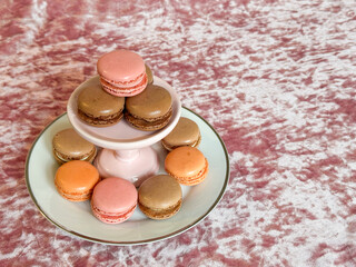 Macarons, cute gluten free dessert cookies on a luxurious pink velvet background