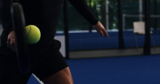 Super slow motion macro of paddle player is serving ball during competition game match or training workout on indoor court at 1000 fps.