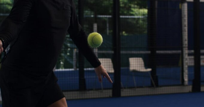 Super slow motion close up of paddle player is serving ball during competition game match or training workout on indoor court at 1000 fps.