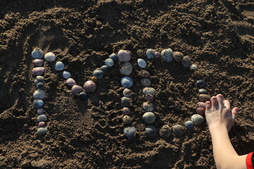 Letras creadas con ostras sobre la arena