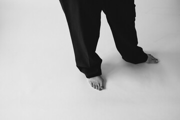 Black and white stylish fashion photography with women's legs. Beautiful female legs in socks or trousers, classic beautiful photo with feet