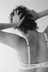 A girl puts on panties and underwear, beautiful delicate black white fashion photograph on a white background. A woman in lingerie and panties, a woman with beautiful hands