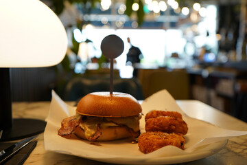 Delicious breakfast burger and hashbrowns on a plate at restaurant