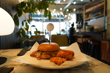 Delicious brioche bun with eggs and bacon served with hashbrowns during breakfast at local diner