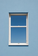  A minimalist photo of a single window frame against a clear blue sky. 