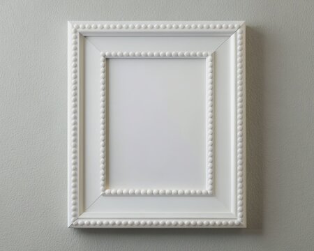 Elegant white photo frame with simple nailhead trim, placed on a clean wall, surrounded by minimal decor, and a hint of natural light.