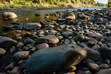 Obraz premium The early morning light casts shadows across the river rocks and boulders as the San Juan River passes by near Pagosa Springs, Colorado