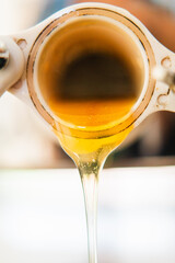 Freshly Extracted Sweet Bee Honey Flowing Out a Barrel Extreme Close Up