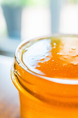 Honey Jar with Sweet Bee Honey Filled to the Brim of the Glass