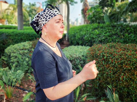 Jogging in a city park, a woman undergoing cancer treatment maintains her fitness routine to help manage chemotherapy's impact.