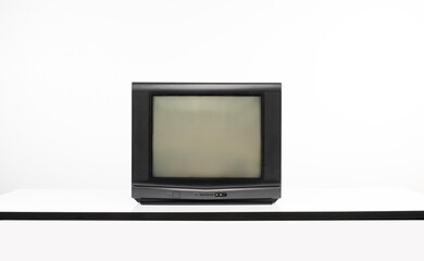 Old TV with blank screen on white table, isolated on white background