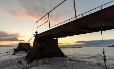 Old broken pier silhouette, winter landscape