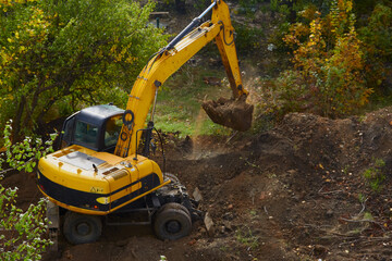 Beginning of construction work: excavator on site., sitework and foundationwork, groundwork; constructionzone and mechanicalwork; sitepreparation and earthmoving