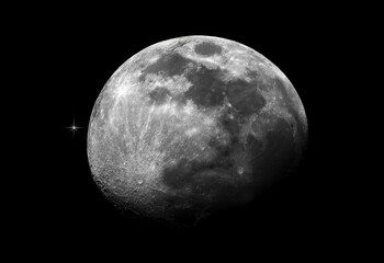 Astronomical photo of the moon with a star in background.