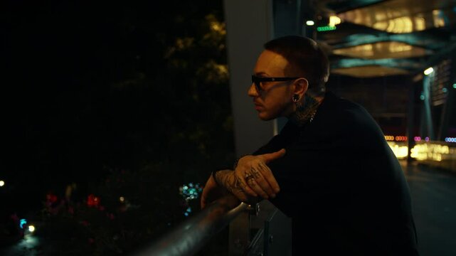 cool guy with tattoos and sunglasses, hanging out in underground subway station, green lights