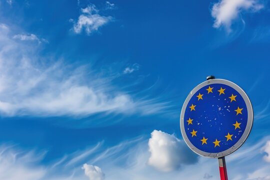 Closeup of a modern road sign with the European Union Flag on blue sky with clouds and copy space