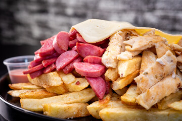 Peruvian culinary: Salchipapas, a fast food made with fried potatos, sausage, egg, bacon and many sauces like ketchup, mayonaise, mustard and hot pepper and chicken