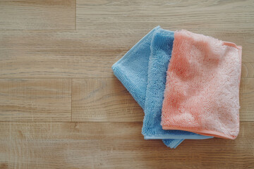 Colorful, folded towels are neatly placed on a wooden floor, evoking a sense of cleanliness, order, and simple, everyday beauty in household routines.