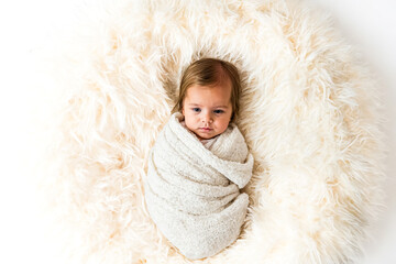 Fototapeta premium Baby girl on a fluffy white rug