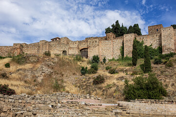Fototapeta premium Ancient ruins of Roman Theater (El Teatro Romano) at foot of famous Malaga Alcazaba fortress, was built in the XI century. Malaga, Andalusia, Spain.