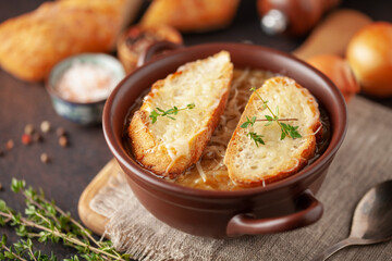 Classic French onion soup baked with cheese croutons sprinkled with fresh thyme